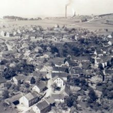 Historische Luftaufnahme des Ortes mit dem Grubenschlot von Schacht III